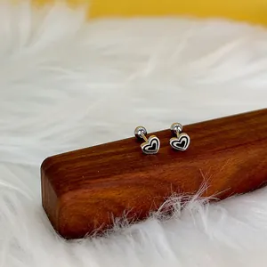 Détails de boucles d'oreilles cœur avec lignes concentriques noires et fermoirs à vis