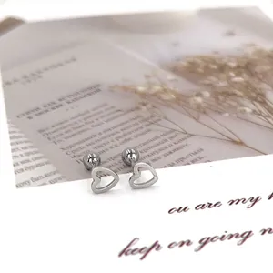 Detailed macro view of hollow heart stud earrings with secure ball screw back closure