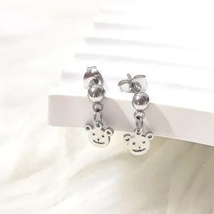 Detail of silver titanium steel bear stud earrings on a white plush background
