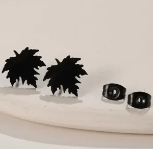 Detailansicht der schwarzen Ohrstecker in Blattform mit mattem Finish auf Tablett
