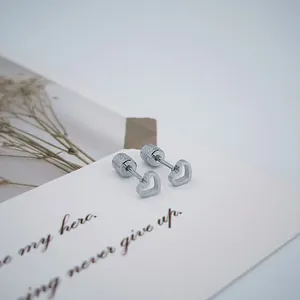 Détail de boucles d'oreilles en cœur ajouré avec fermoir à vis sécurisé sur carte