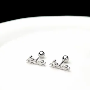 Detalle macro de pendientes 'love' plateados con cierre de rosca de bola seguro