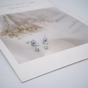 Vue détaillée de boucles d'oreilles fantômes en argent avec fermoir à vis sur carte