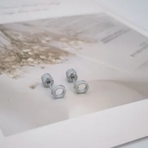 Détails macro de boucles d'oreilles géométriques argentées avec fermoirs à vis sécurisés