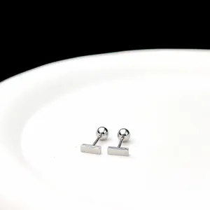 Primer plano de pendientes rectangulares de plata con cierre de bola minimalista