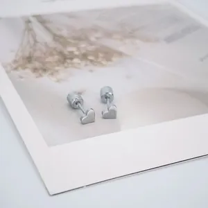 Vue détaillée de boucles d'oreilles cœur en argent avec fermoir à vis sur carte fleurie