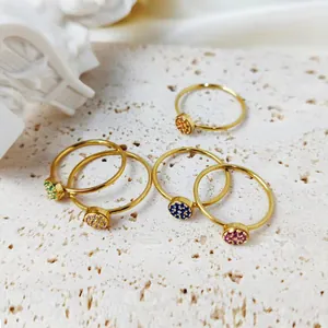 Set of five gold thin bands with colorful round cubic zirconia birthstones on stone