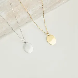 Detailaufnahme der 14K Gold und Silber Oval-Anhänger Halsketten auf Stein-Hintergrund