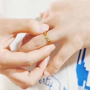 Vue détaillée d'une bague chaîne en acier inoxydable plaqué or 14K sur l'index