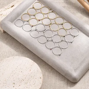 Macro display of minimalist birthstone rings with colorful cubic zirconia in a jewelry tray