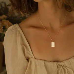 Nahaufnahme einer minimalistischen goldenen Rechteck-Halskette an einem Frauenmodel