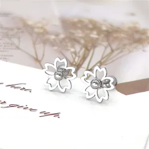Detailopname van minimalistische madeliefje oorknopjes met parel op een geschenkkaart
