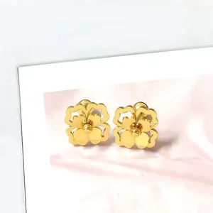 Detailopname van de gouden madeliefje oorbellen met dubbellaagse blaadjes en glans