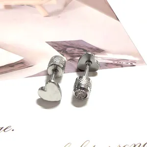 Detalle macro de los pendientes de corazón plateados con pernos roscados y circonitas claras