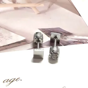 Detalle de pendiente de acero inoxidable plateado con moleteado y piedra de circón redonda