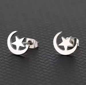 Macro shot of silver crescent moon and star stud earrings with polished metal finish