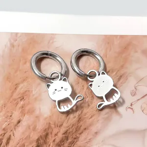 Detalle de pendientes de aro en acero inoxidable con colgantes de gatos blancos