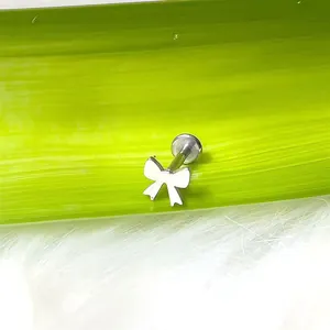 Dettaglio ravvicinato di un piercing a fiocco argento con chiusura a base piatta labret