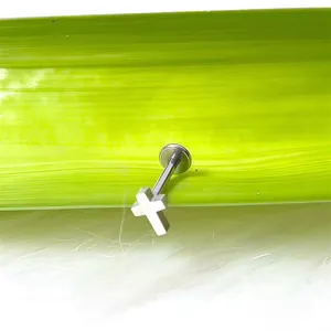 Dettaglio del piercing labret a croce argento su foglia per orecchio e labbro