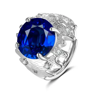 Détail d'une bague en argent avec une grande pierre bleue et texture d'écorce