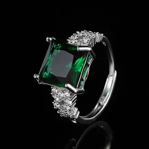 Macro detail of square green emerald ring with pavé diamonds on adjustable silver band