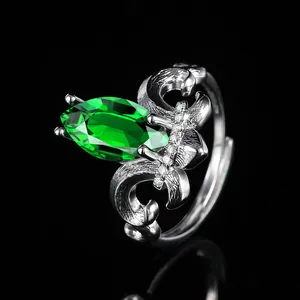 Macro shot of marquise-cut green gemstone on vintage silver crown ring with micro-pave details