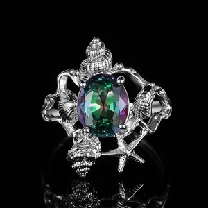 Macro shot of silver ring with colorful oval gemstone and ocean seashell details