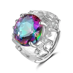 Détail d'une bague avec gemme arc-en-ciel, anneau argenté ondulé et éclats de diamants