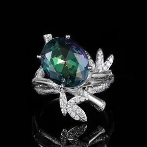 Macro shot of oval mystic topaz ring with bamboo textured band and diamond leaves