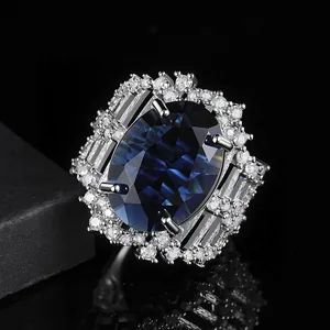 Luxe zilveren ring met grote ovale blauwe saffier en witte diamantaccenten op zwart