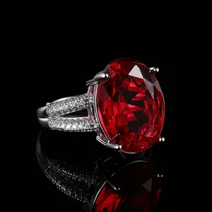 Macro zijaanzicht van een ovale robijnen ring met pavé-diamanten op zilveren banden