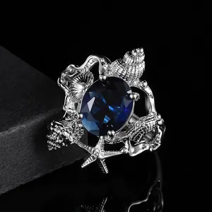 Elegant ocean shell ring with blue oval stone and starfish details in silver finish