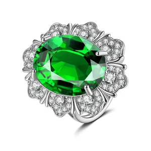 Makroaufnahme Ring mit grünem ovalem Kristall und mehrschichtigen Zirkonia-Blüten