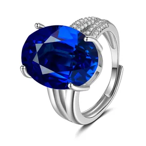 Close-up van zilveren ring met grote ovale blauwe steen en zirkonia-pavézetting
