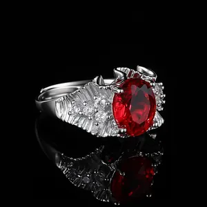 Gros plan sur une bague sertie d'une grande gemme rouge ovale et de petits diamants