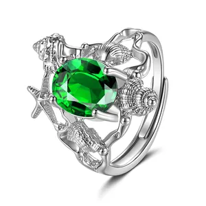 Macro view of ocean-themed ring featuring green main stone with seashell and starfish details