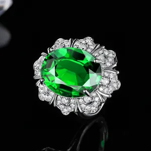 Makroaufnahme eines Luxus-Ringes mit ovalem grünem Edelstein und funkelndem Diamantkranz