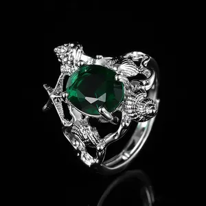 Detailed view of silver sea shell ring with large green gemstone and starfish relief