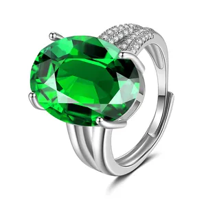 Detail van een ring met ovale groene edelsteen en pavé diamanten in zilveren zet