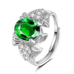 Détail d'une pierre verte ovale et de diamants blancs sur une bague réglable en argent