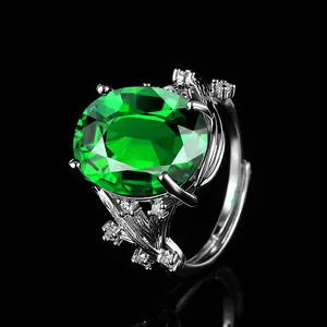 Luxury silver floral branch ring featuring a large oval green sapphire and white accents