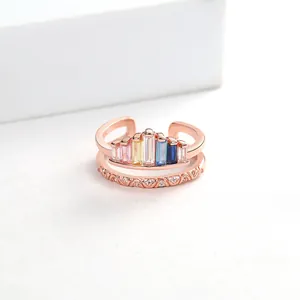 Detail view of rose gold crown ring with colorful rectangular gems and wavy diamond band