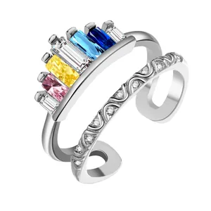 Close-up of rainbow crown ring with colorful rectangular gems and zircon wave band