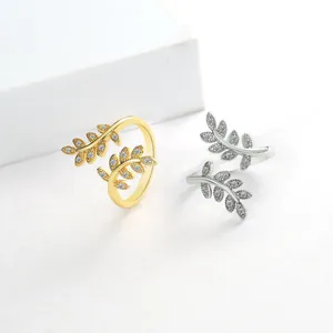 Detailed view of silver and gold olive leaf rings with shimmering crystals in open design