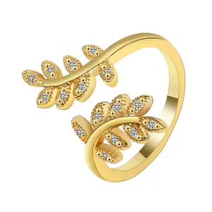 Adjustable gold olive leaf branch ring with sparkling pavé zircons on white background