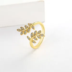 Macro view of gold olive branch open ring featuring sparkling white zircon stones