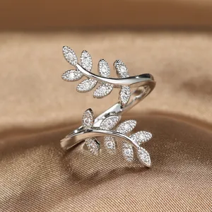 Polished silver olive leaf open ring with sparkling pavé crystals on silk background