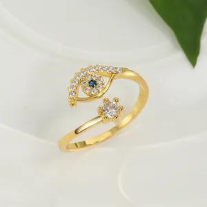 Macro detail of gold open ring featuring blue evil eye charm and clear zircon stone
