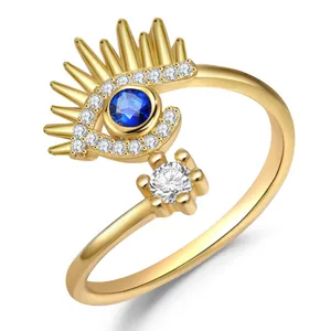 Anillo abierto Evil Eye chapado en oro con piedra azul y cristales sobre fondo blanco