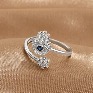 Dettaglio anello Hamsa d'argento con pietra blu e zirconi su seta dorata di lusso